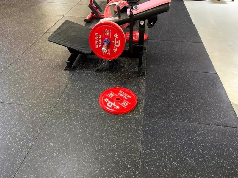 A clean, modern gym locker room with grey wood-look luxury vinyl tile flooring.
